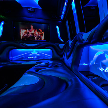 Blue LED mood lights illuminate the coolers and seats in this party bus.