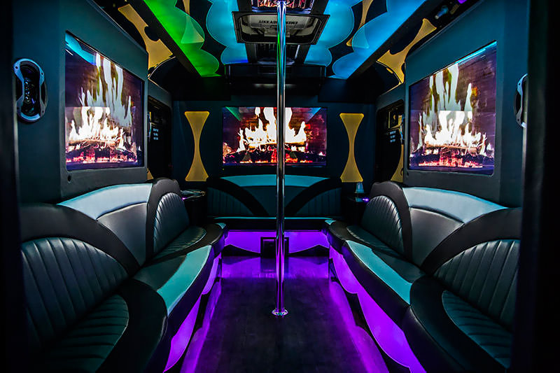 Multi colored LED lights illuminate the leather seats and hardwood floor of this party bus.