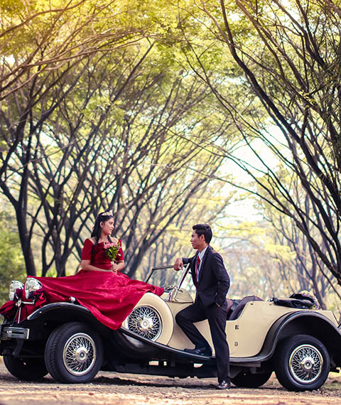 Prom Couple posing with a classic car