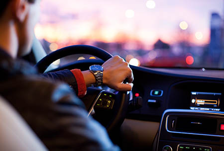 A chauffeur driving a luxury vehicle on the streets of Grand Rapids